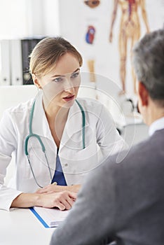 Female doctor talking to her patient in doctorÃ¢â¬â¢s office photo